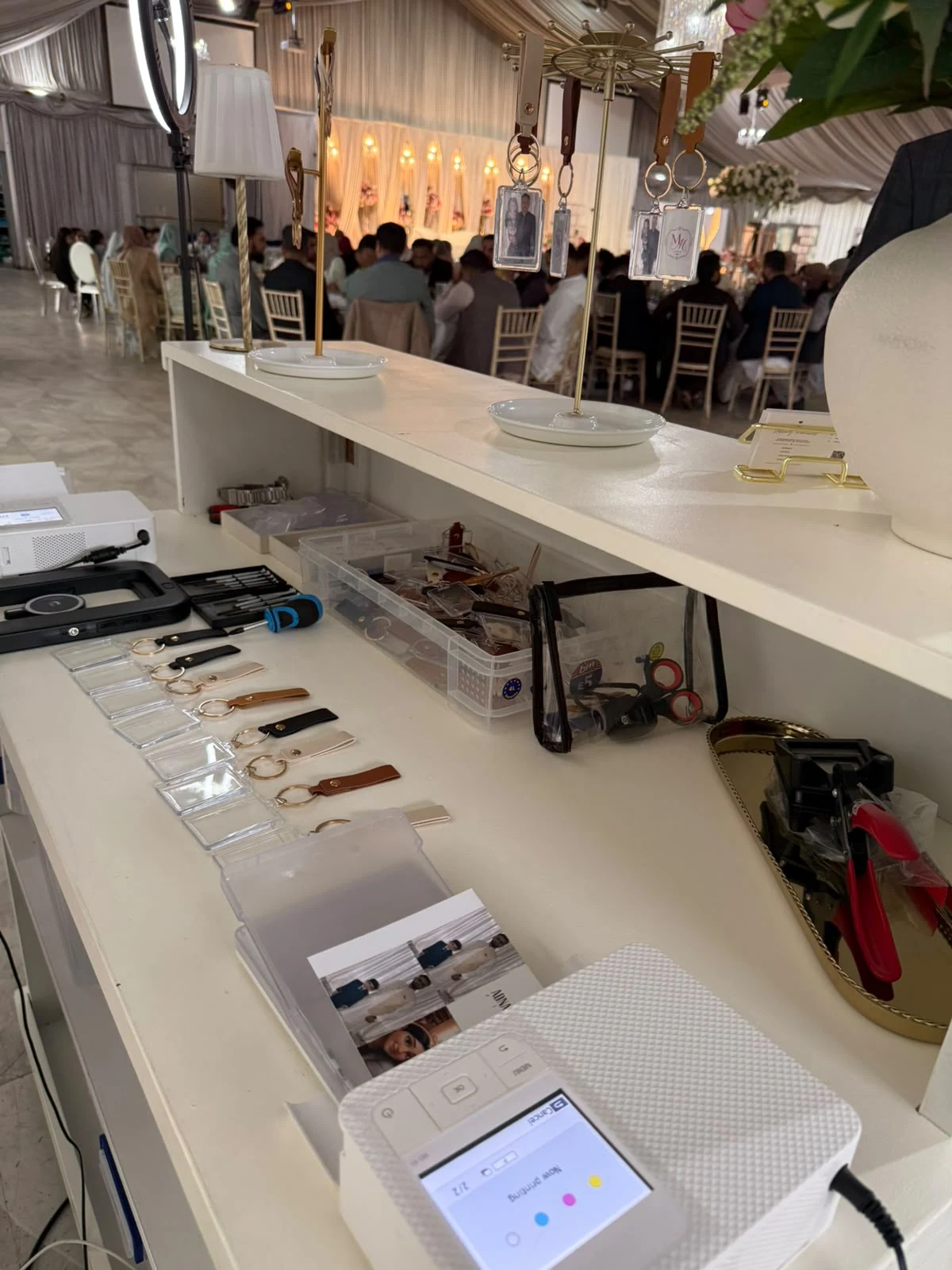 The working side of the Keepsake Bar with keyring materials and printing equipment during an event
