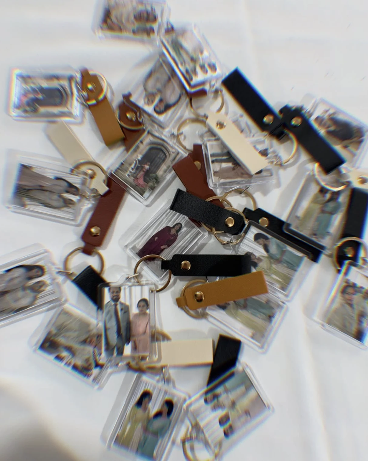 Dozens of finished personalised photo keyrings scattered across a white cloth